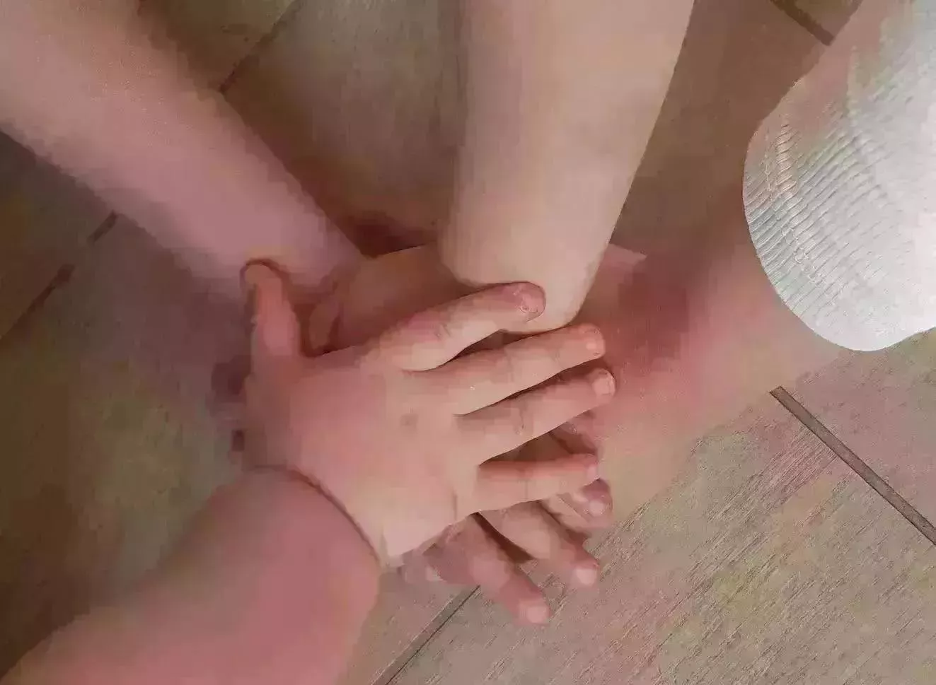 Hände eines Baby liegen auf der Hand der Eltern