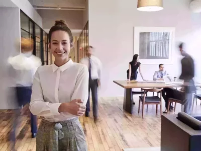 Eine Frau steht in einem Raum mit Menschen im Hintergrund.