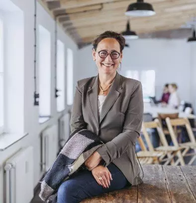 Eine Frau sitzt auf einem Holztisch.