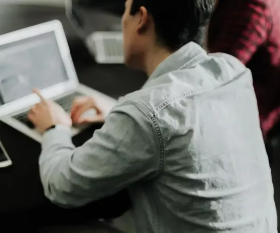 Enno Deckardt nutzt einen Laptop an einem Tisch.