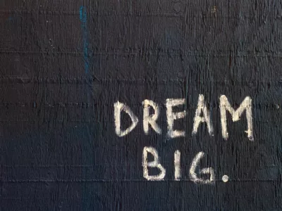 Dream Big auf schwarze Wand geschrieben