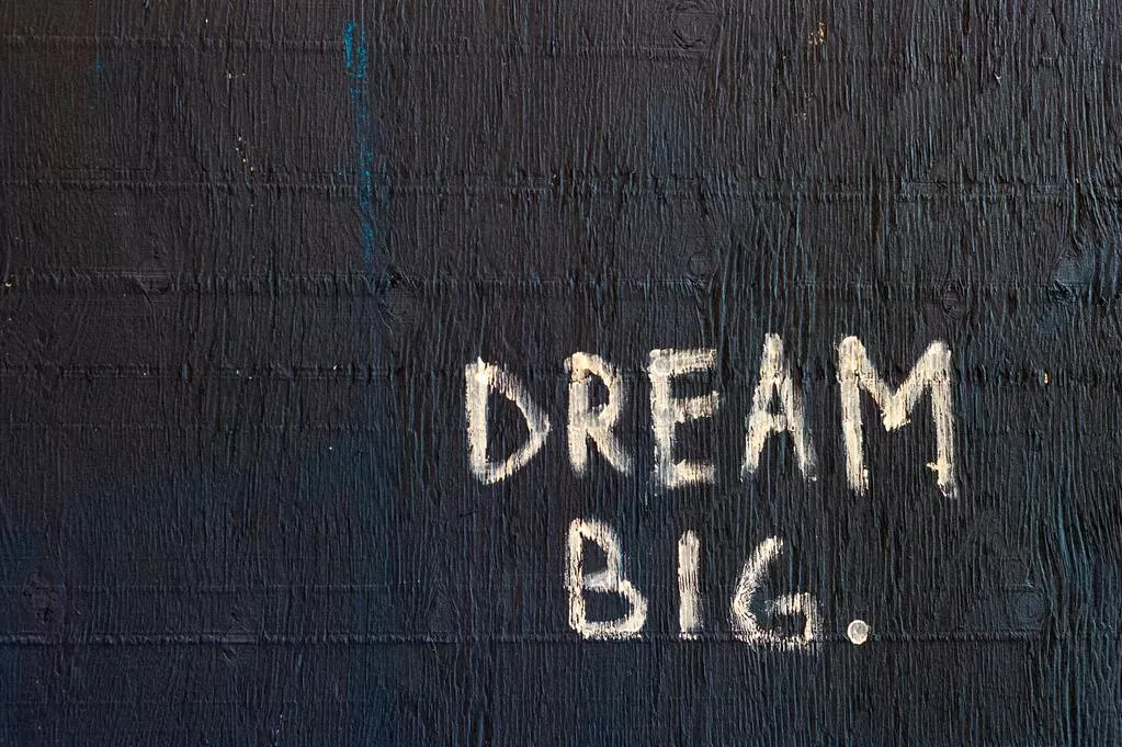 Dream Big auf schwarze Wand geschrieben