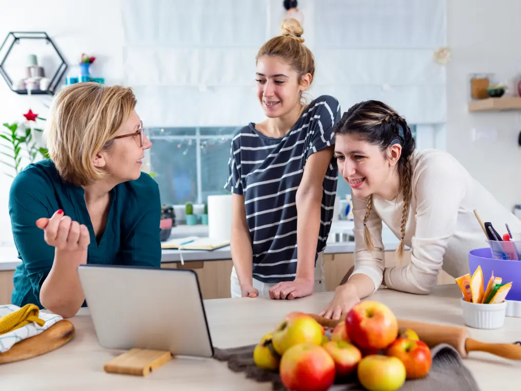 Eine Gruppe von Frauen steht um einen Laptop herum.