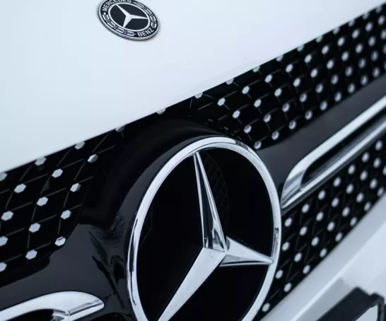 Eine Nahaufnahme eines Mercedes-Logos auf einem Auto.