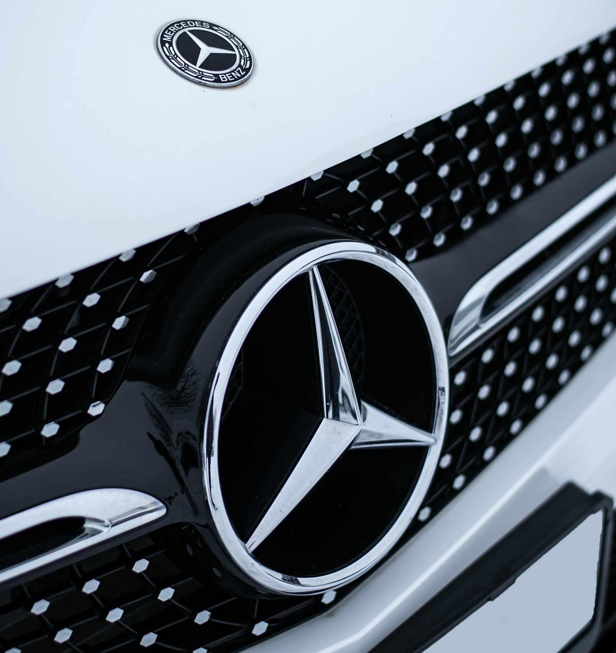 Eine Nahaufnahme eines Mercedes-Logos auf einem Auto.