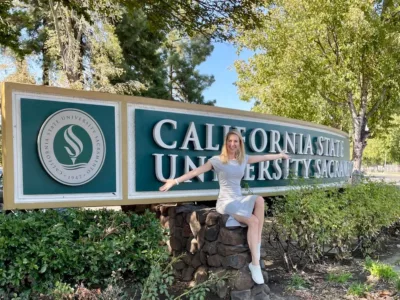 Hendrikje Lyhs sitzt auf einem Schild der California State University