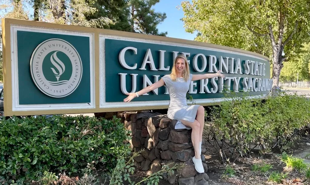 Hendrikje Lyhs sitzt auf einem Schild der California State University