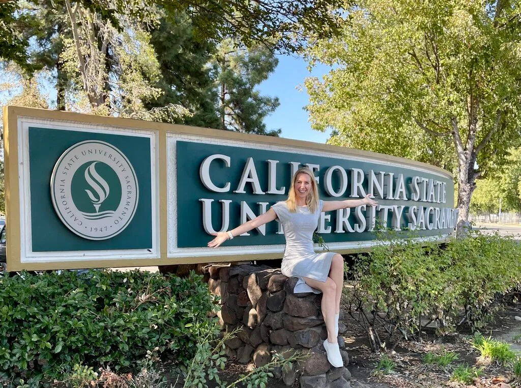 Hendrikje Lyhs sitzt auf einem Schild der California State University