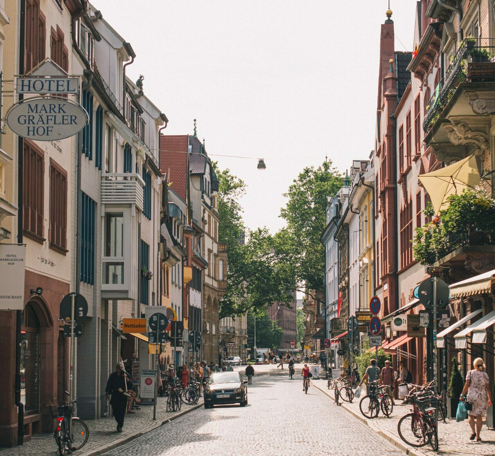 Eine Stadtstraße mit Menschen, die zu Fuß gehen und Fahrrad fahren.