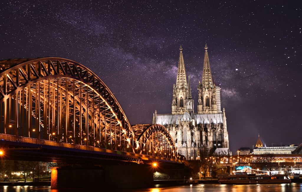 eine Nachtansicht einer Kathedrale und einer Brücke.