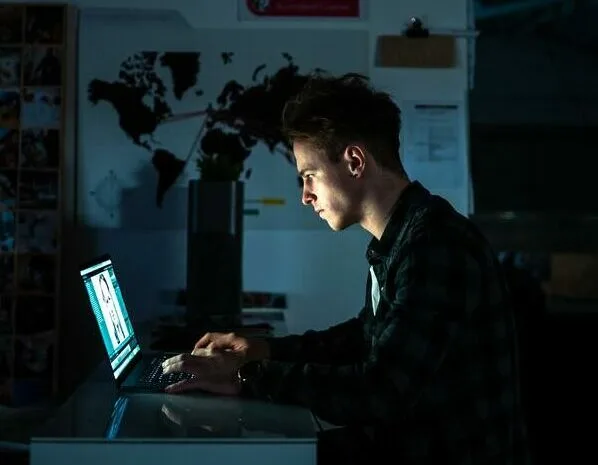 Ein Mann schreibt Prüfungen der AKAD auf einem Laptop an seinem Schreibtisch.