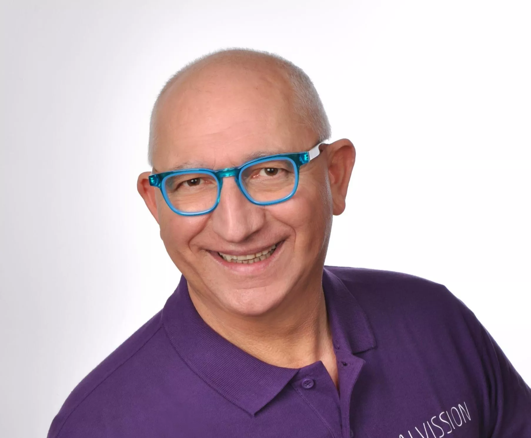 Frank Tassone mit lila Poloshirt und blauer Brille