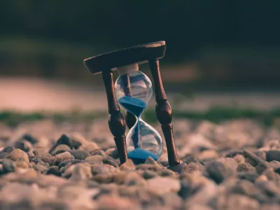 Eine Sanduhr mit blauem Sand am Strand