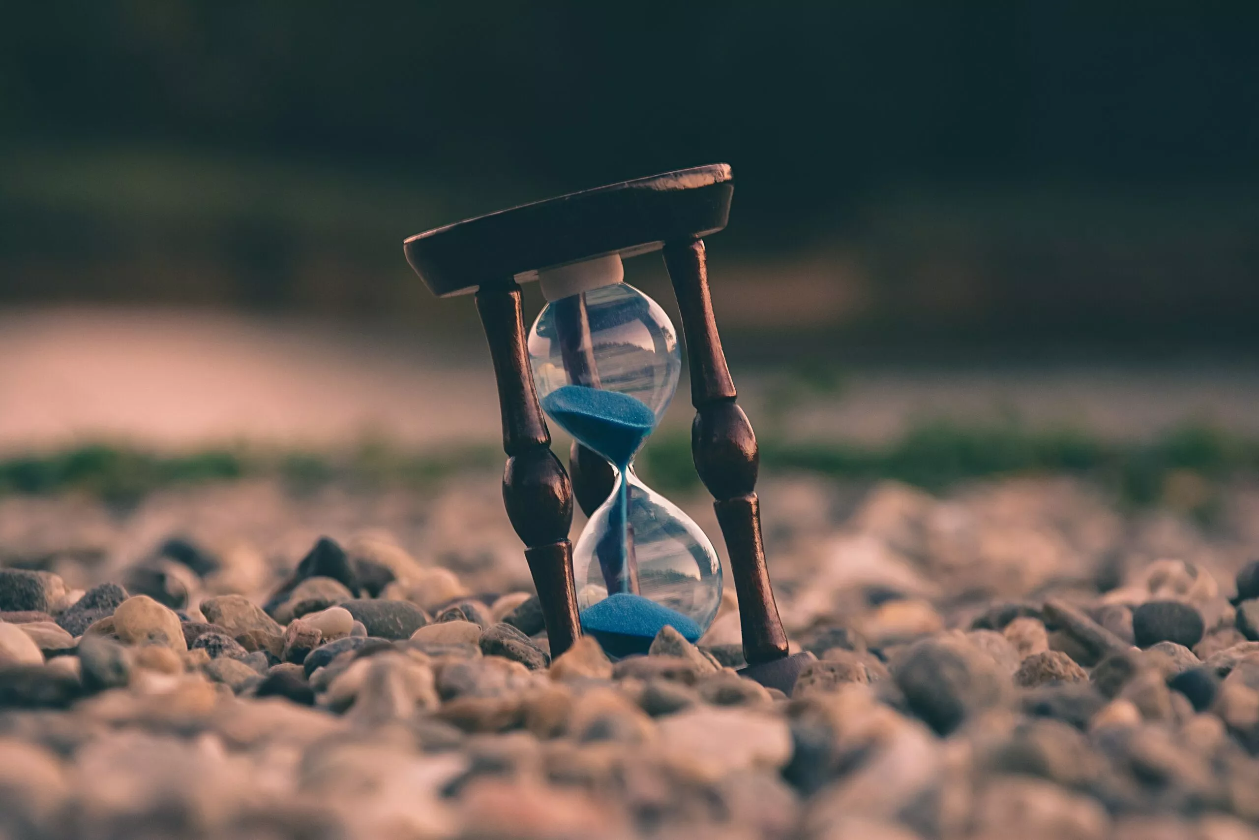 Eine Sanduhr mit blauem Sand am Strand