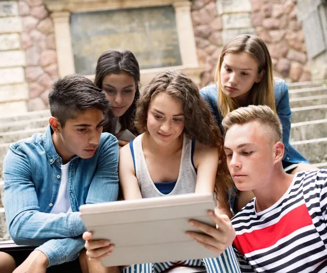 Eine Gruppe von Menschen, die auf ein Tablet schauen