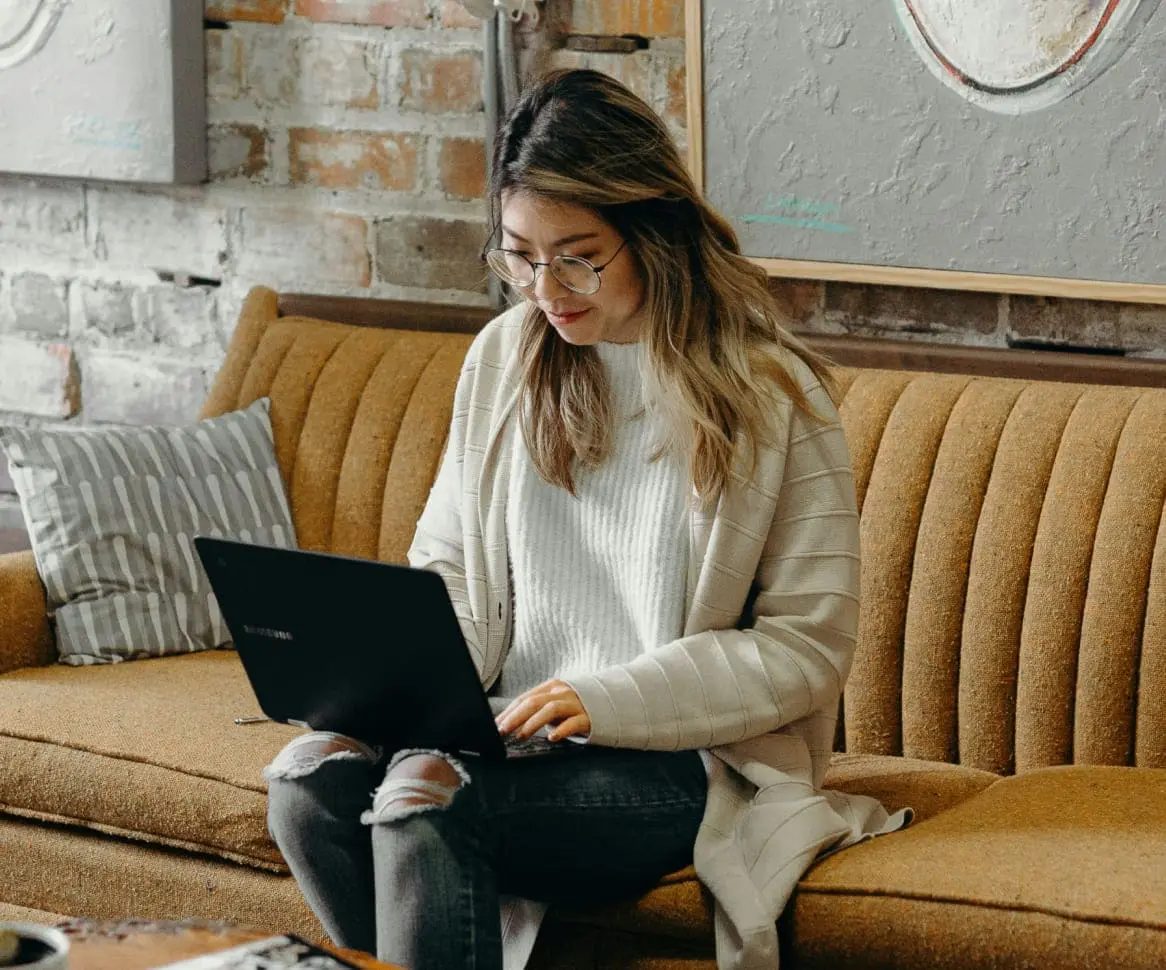 [15:54] Biesinger, Jan Studierende sitzt auf einer braunen Couch und studiert mit ihrem Laptop auf dem Schoß