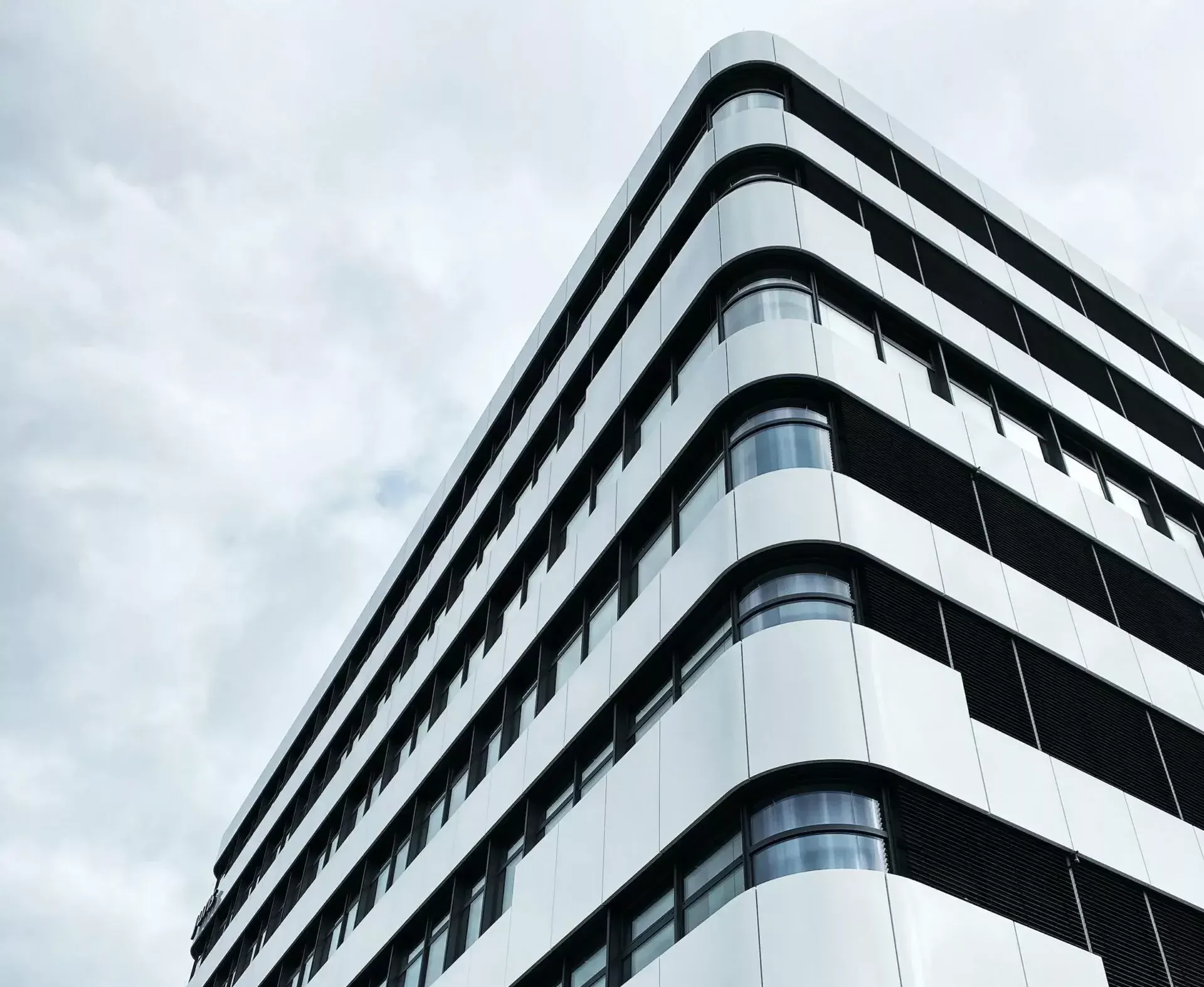 Ein hohes weißes Gebäude mit vielen Fenstern.