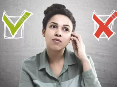 Eine Studentin schaut nachdenklich vor grauem Hintergrund. Neben ihrem Gesicht befindet sich 2 Checkboxen.