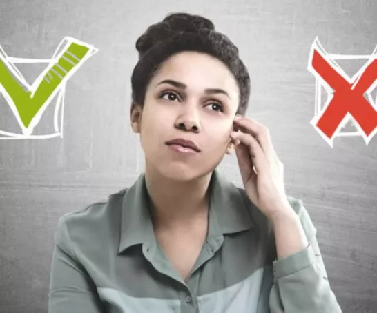 Eine Studentin schaut nachdenklich vor grauem Hintergrund. Neben ihrem Gesicht befindet sich 2 Checkboxen.