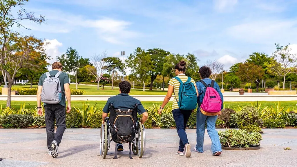 Studenten mit Rucksäcken befinden sich gemeinsam in einem Park