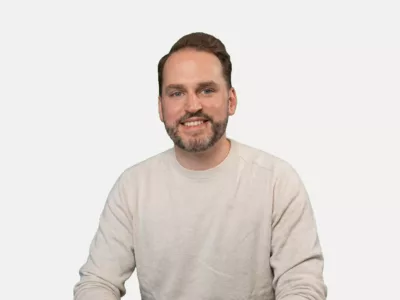 Dominik Breitbach sitzend vor weißem Hintergrund