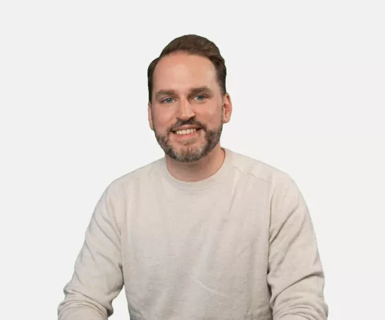 Dominik Breitbach sitzend vor weißem Hintergrund