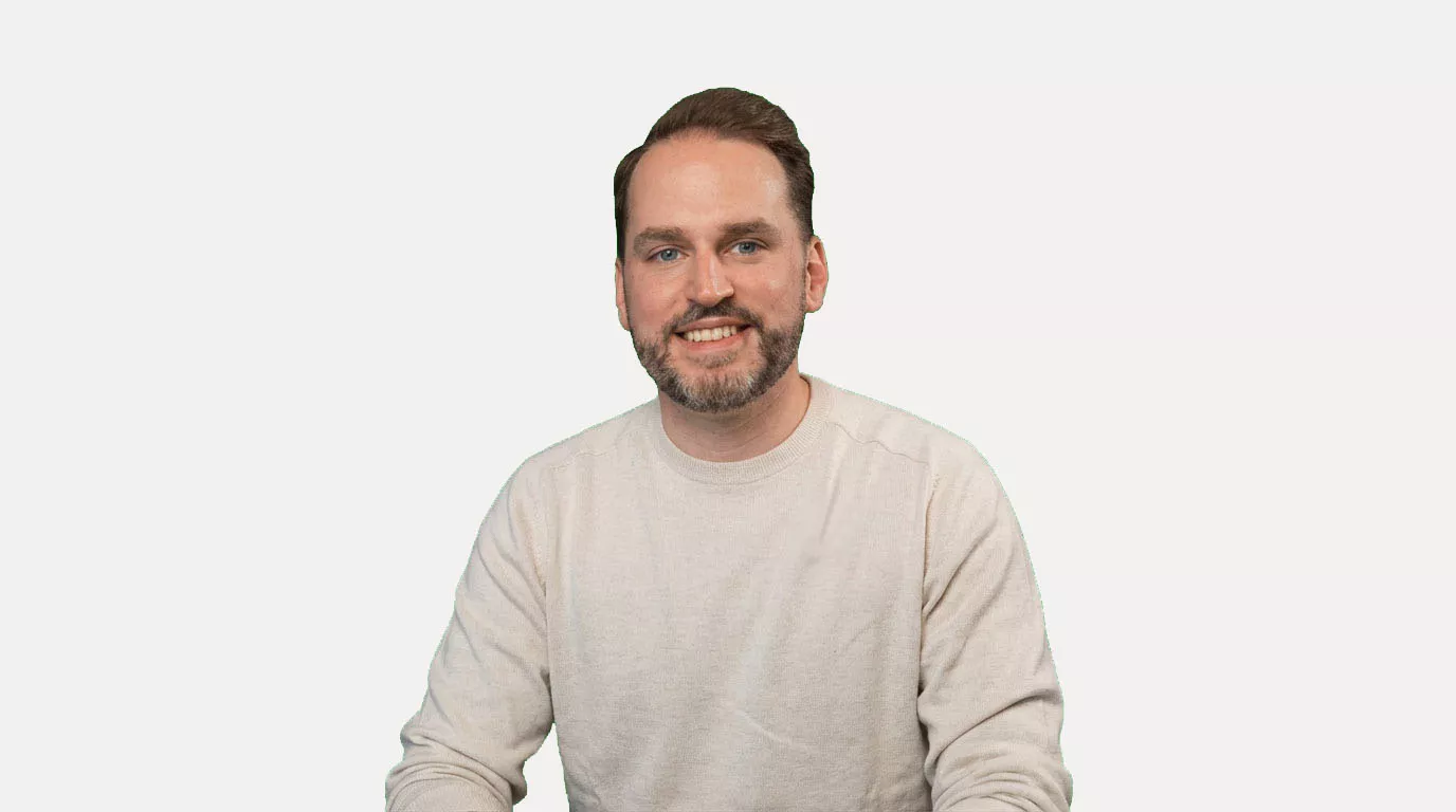 Dominik Breitbach sitzend vor weißem Hintergrund